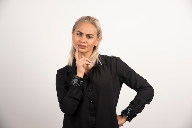 Retrato de mujer hermosa en camisa negra posando sobre fondo blanco. Foto de alta calidad