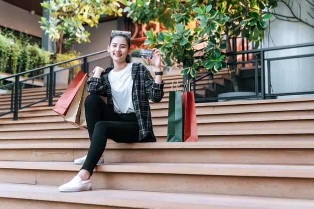 Retrato mujer hermosa colocar anteojos en la cabeza sosteniendo la bolsa de compras