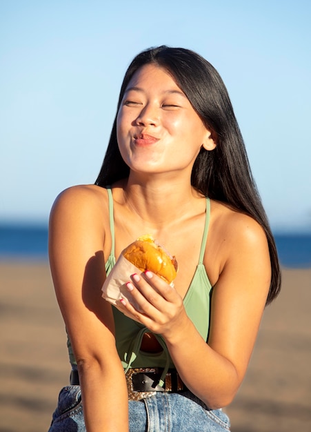 Retrato de mujer hermosa comiendo comida de la calle