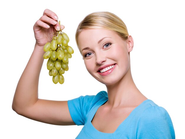 Retrato de una mujer hermosa feliz con racimo de uvas