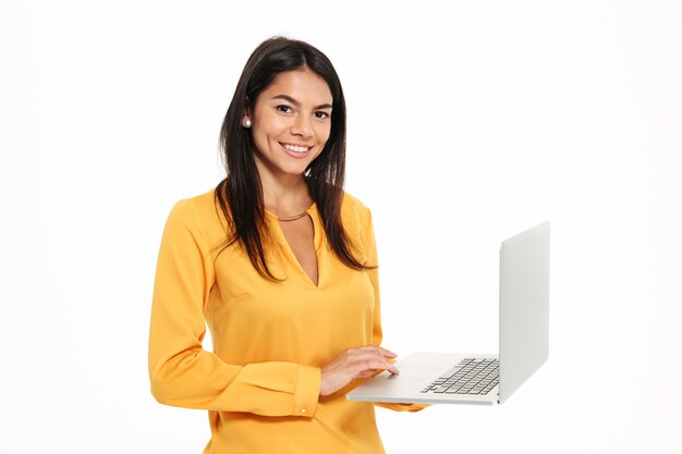 Retrato de una mujer hermosa y feliz sosteniendo una computadora portátil