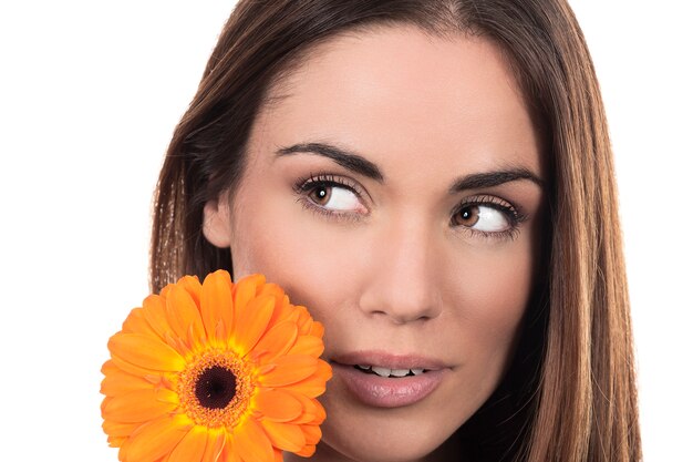 Retrato de mujer hermosa con flor sobre fondo blanco.