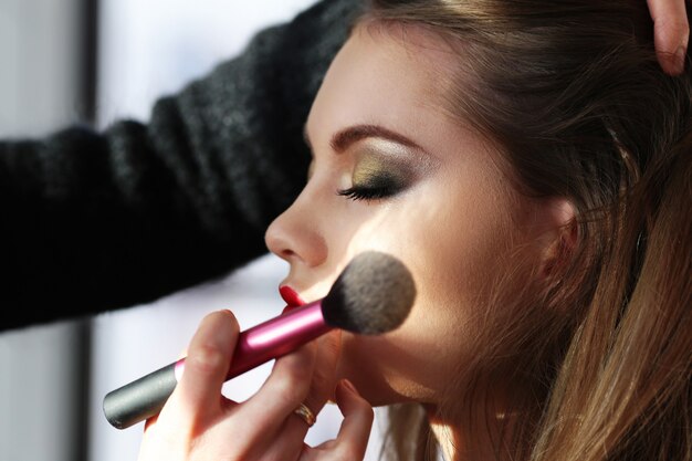 Retrato de mujer hermosa haciendo maquillaje