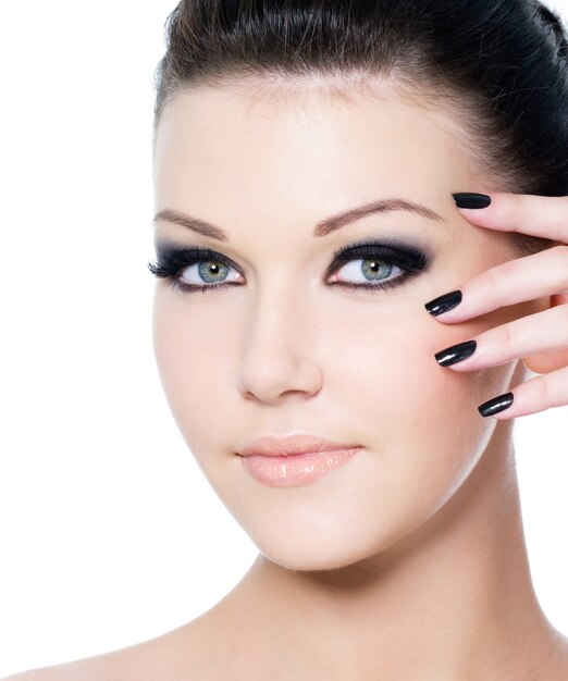 Retrato de una mujer hermosa joven con manicura y maquillaje negro de moda