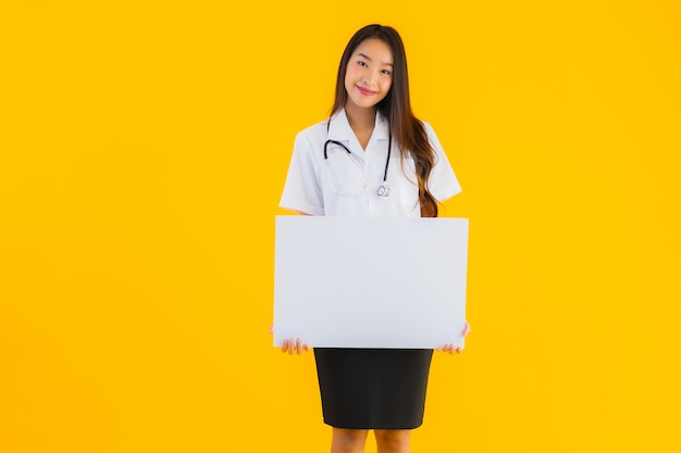 Retrato de mujer hermosa joven médico asiático con pizarra vacía