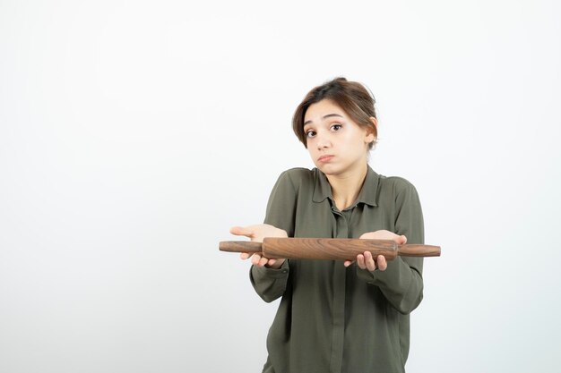 Retrato de mujer hermosa joven con rodillo de madera. foto de alta calidad