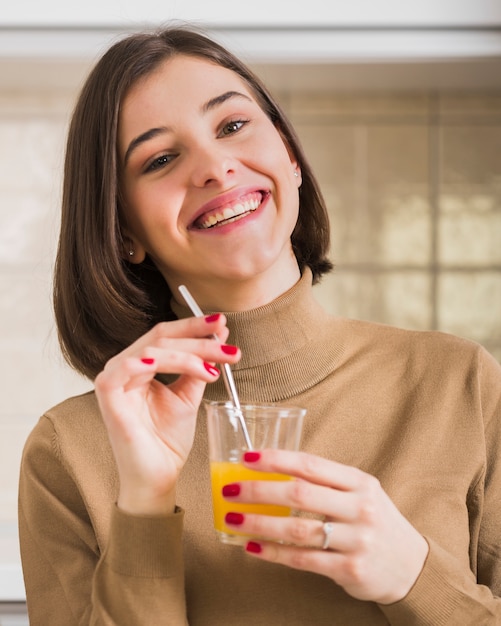 Retrato de mujer hermosa con jugo de naranja