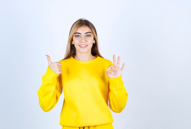 Retrato de mujer hermosa modelo apuntando hacia arriba y haciendo gesto bien