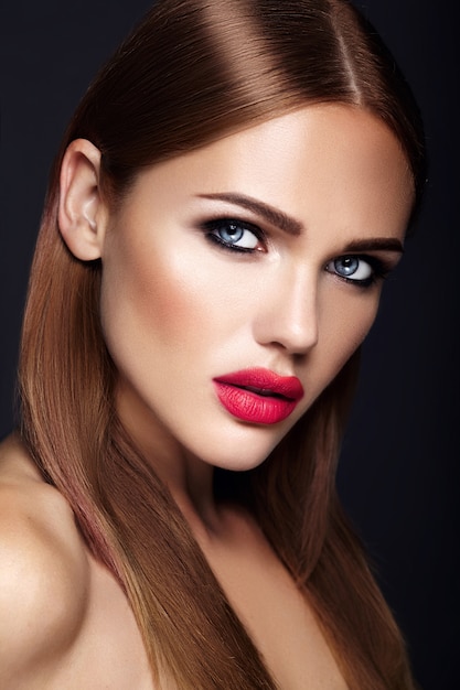 Retrato de mujer hermosa modelo con maquillaje de noche y peinado romántico. labios rojos