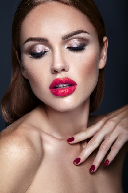 Retrato de mujer hermosa modelo con maquillaje de noche y peinado romántico. labios rojos