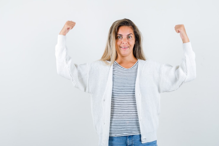 Foto gratuito retrato de mujer hermosa mostrando gesto ganador en chaqueta y mirando feliz vista frontal