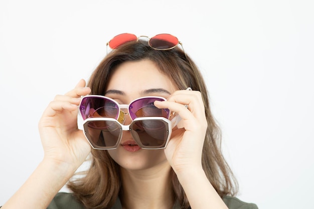 Retrato de mujer hermosa con muchas gafas de sol sobre blanco. foto de alta calidad