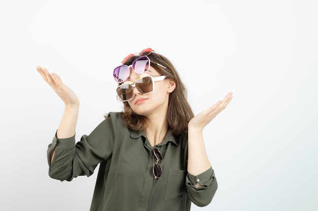 Retrato de mujer hermosa con muchas gafas de sol sobre blanco. foto de alta calidad