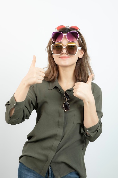 Retrato de mujer hermosa con muchas gafas de sol sobre blanco. foto de alta calidad