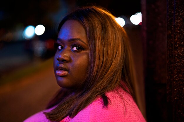 Retrato de mujer hermosa por la noche en las luces de la ciudad