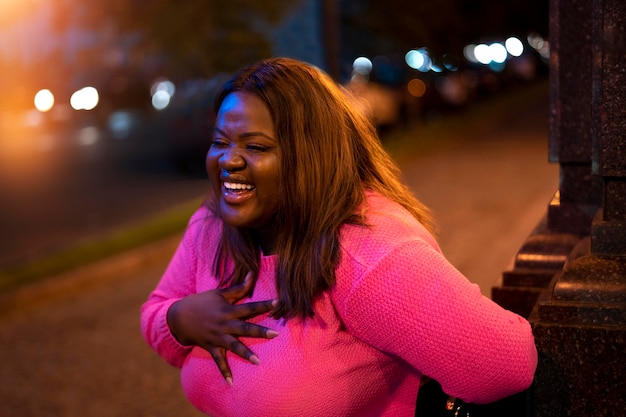 Retrato de mujer hermosa por la noche en las luces de la ciudad