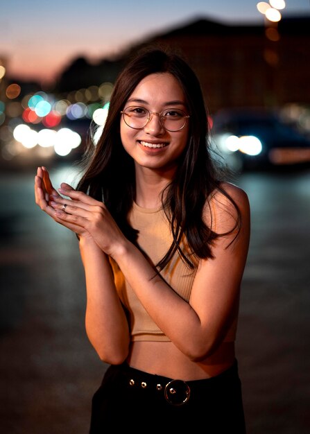 Retrato de mujer hermosa por la noche en las luces de la ciudad