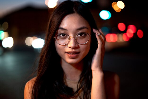 Retrato de mujer hermosa por la noche en las luces de la ciudad