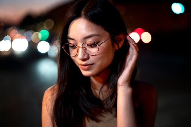 Retrato de mujer hermosa por la noche en las luces de la ciudad