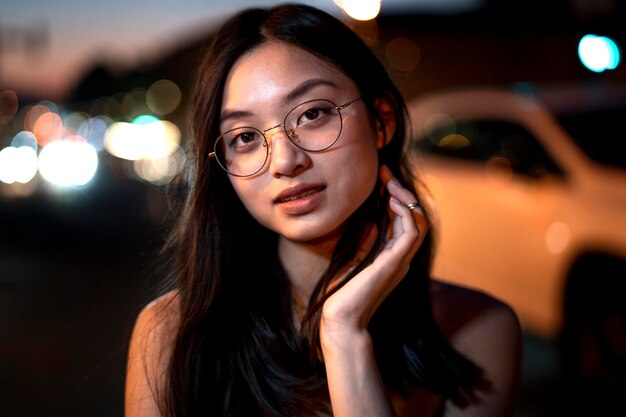 Retrato de mujer hermosa por la noche en las luces de la ciudad