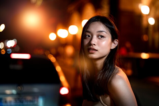 Foto gratuita retrato de mujer hermosa por la noche en las luces de la ciudad