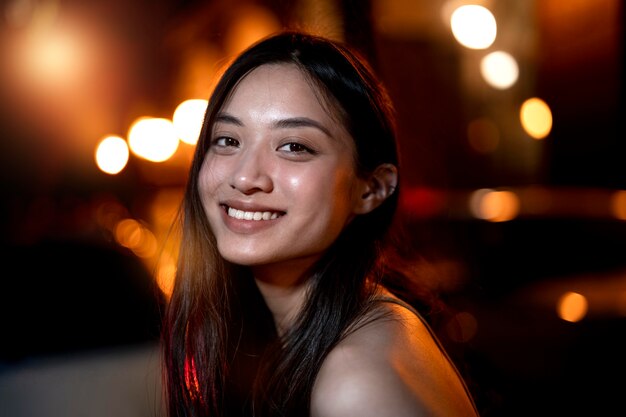 Retrato de mujer hermosa por la noche en las luces de la ciudad