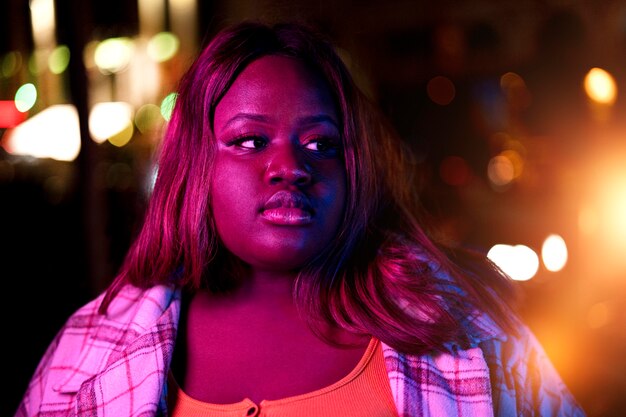 Retrato de mujer hermosa por la noche en las luces de la ciudad