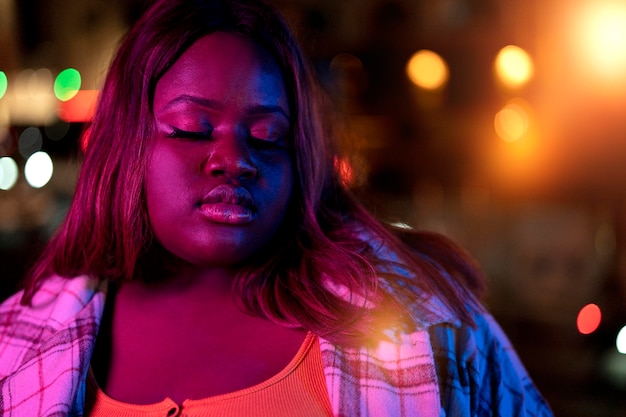 Retrato de mujer hermosa por la noche en las luces de la ciudad