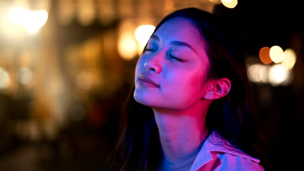 Retrato de mujer hermosa por la noche en las luces de la ciudad