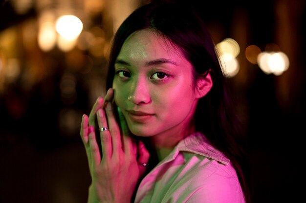 Retrato de mujer hermosa por la noche en las luces de la ciudad