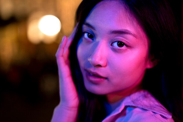 Retrato de mujer hermosa por la noche en las luces de la ciudad