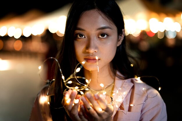 Retrato de mujer hermosa por la noche en las luces de la ciudad