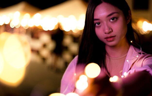 Retrato de mujer hermosa por la noche en las luces de la ciudad