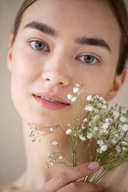 Retrato de mujer hermosa con piel clara posando con flores de aliento de bebé