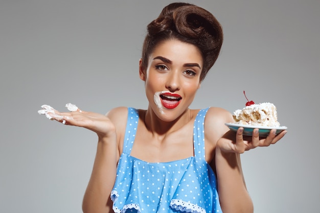 Foto gratuita retrato de mujer hermosa pin-up comiendo pastel