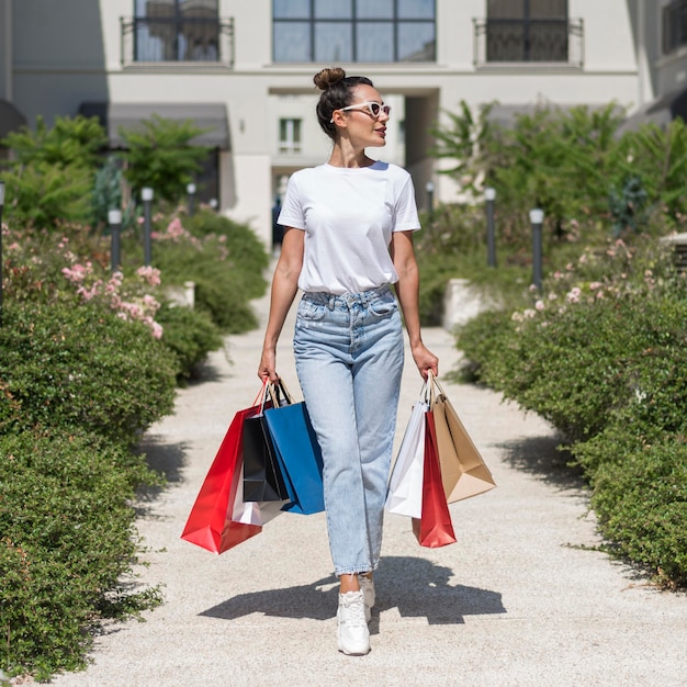 Retrato de mujer hermosa posando con bolsas de la compra.