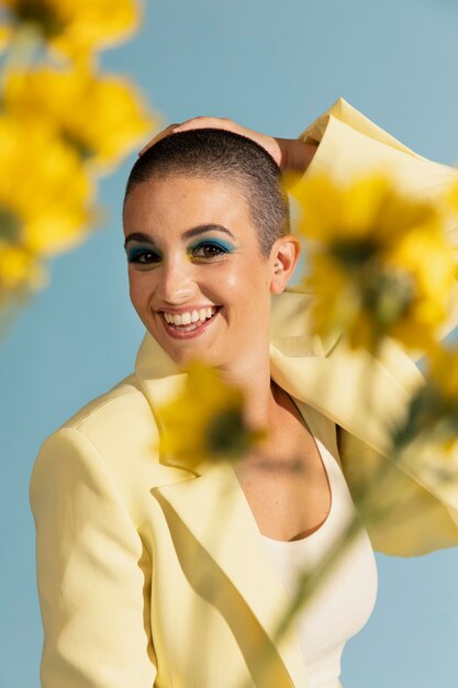 Retrato de mujer hermosa posando con una chaqueta amarilla y flores