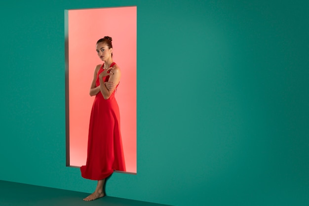 Retrato de mujer hermosa posando en un vestido rojo fluido con espacio de copia