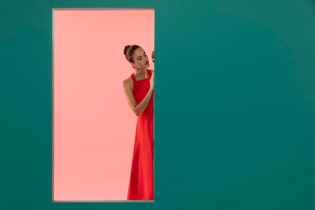 Foto gratuita retrato de mujer hermosa posando en un vestido rojo fluido con espacio de copia