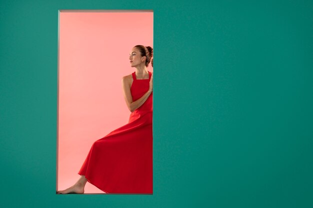 Retrato de mujer hermosa posando en un vestido rojo fluido con espacio de copia