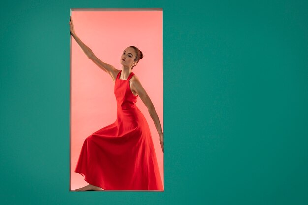 Retrato de mujer hermosa posando en un vestido rojo fluido con espacio de copia