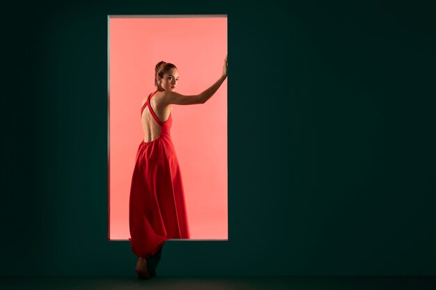 Retrato de mujer hermosa posando con un vestido rojo fluido