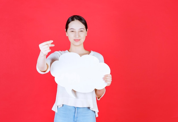 Retrato de mujer hermosa que sostiene el bocadillo de diálogo con forma de nube