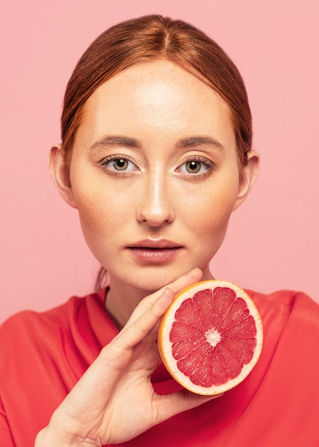 Retrato de mujer hermosa sosteniendo una fruta