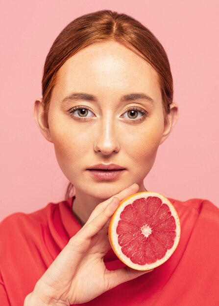 Retrato de mujer hermosa sosteniendo una fruta