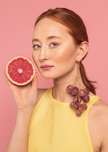 Retrato de mujer hermosa sosteniendo una fruta