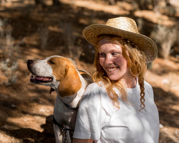 Retrato de mujer hermosa y su perro mirando a otro lado