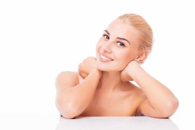 Retrato de mujer hermosa tocando su piel de la cara y sonrisa