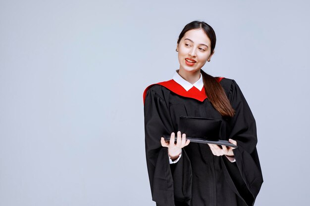 Retrato de mujer hermosa en traje de graduación de pie sobre la pared. Foto de alta calidad