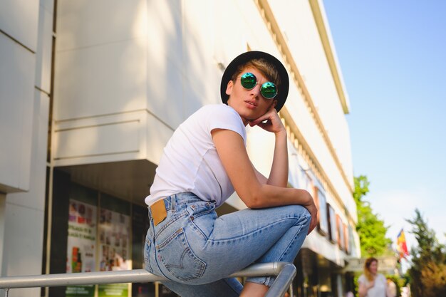 Retrato de mujer hipster con maquillaje natural y corte de pelo corto disfrutando del tiempo libre al aire libre